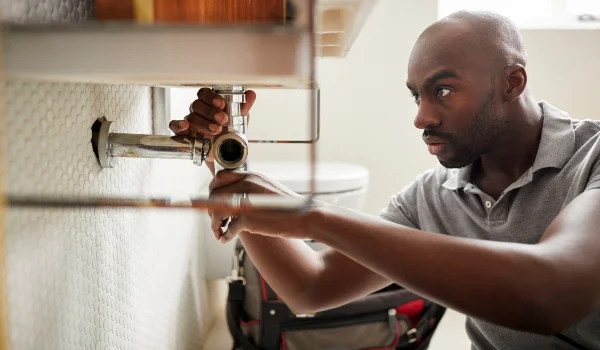 a male plumber fixing a bathroom faucet from Emergency Plumber Kyle in Kyle, TX - Kyle, TX